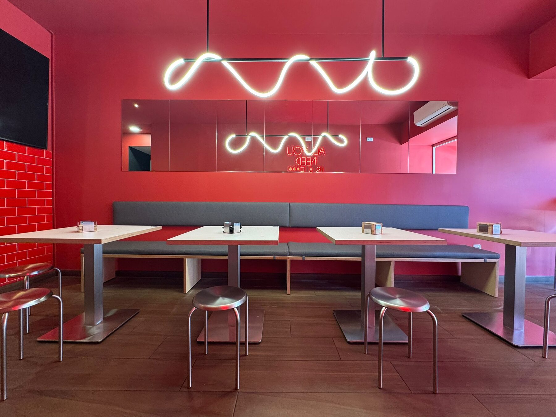 Restaurante Delirio con paredes rojas y lámparas onduladas