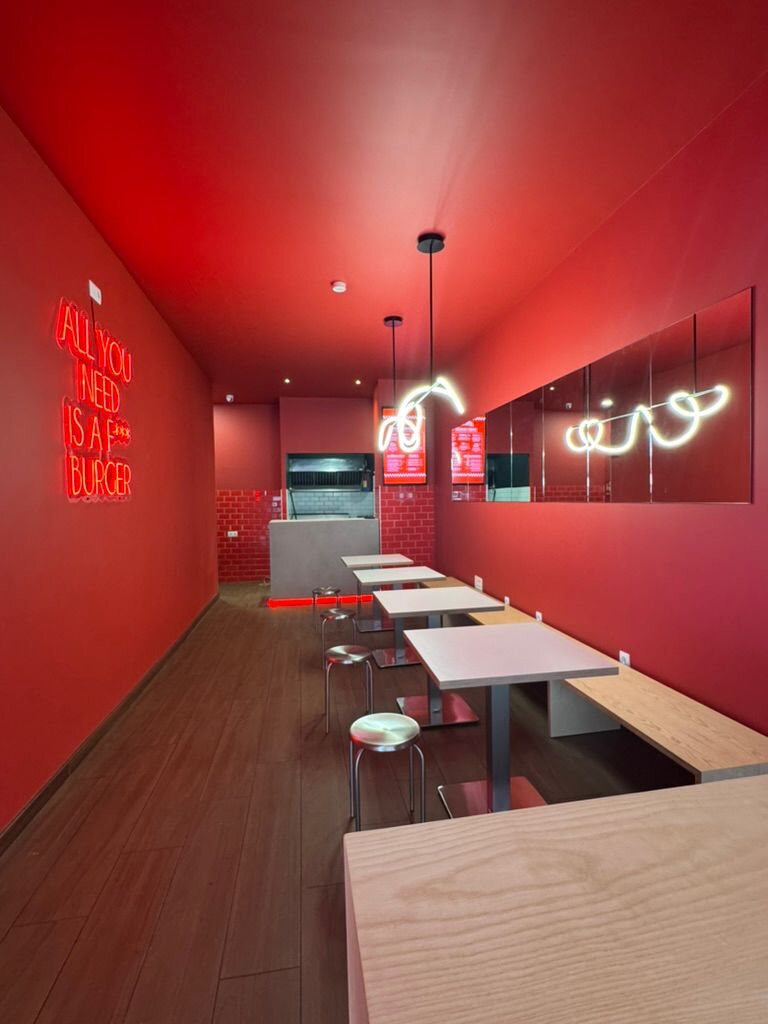 Interior del restaurante Delirio con bancos y paredes rojas