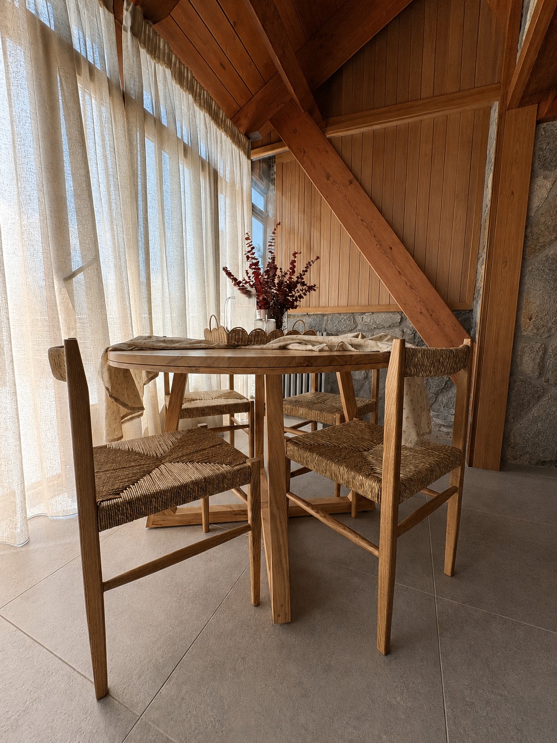 Comedor en Formigal con mesa de madera bajo cubierta inclinada