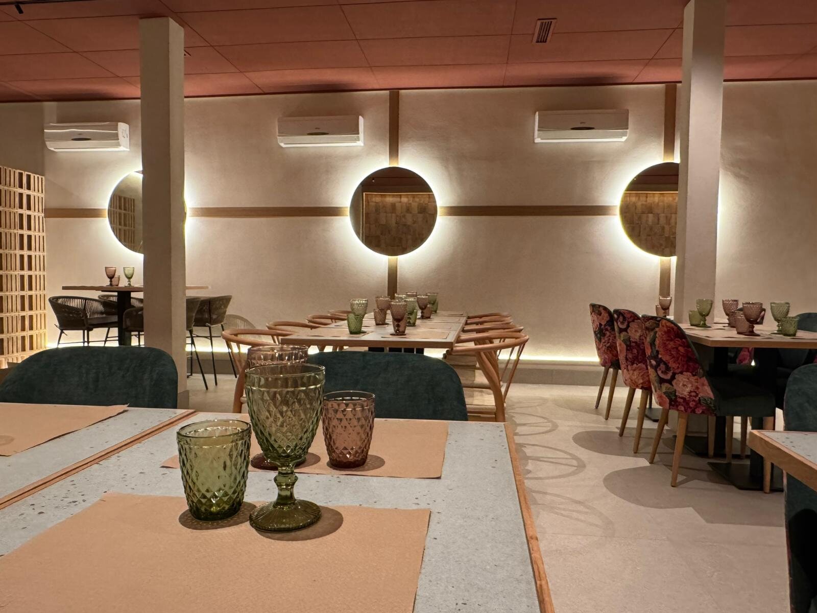 Restaurante con iluminación cálida y banqueta junto a las mesas