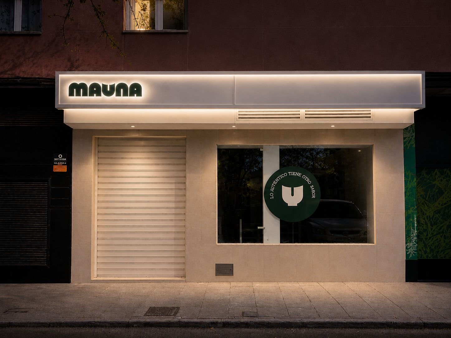 Fachada de cafetería Mauna con letrero iluminado