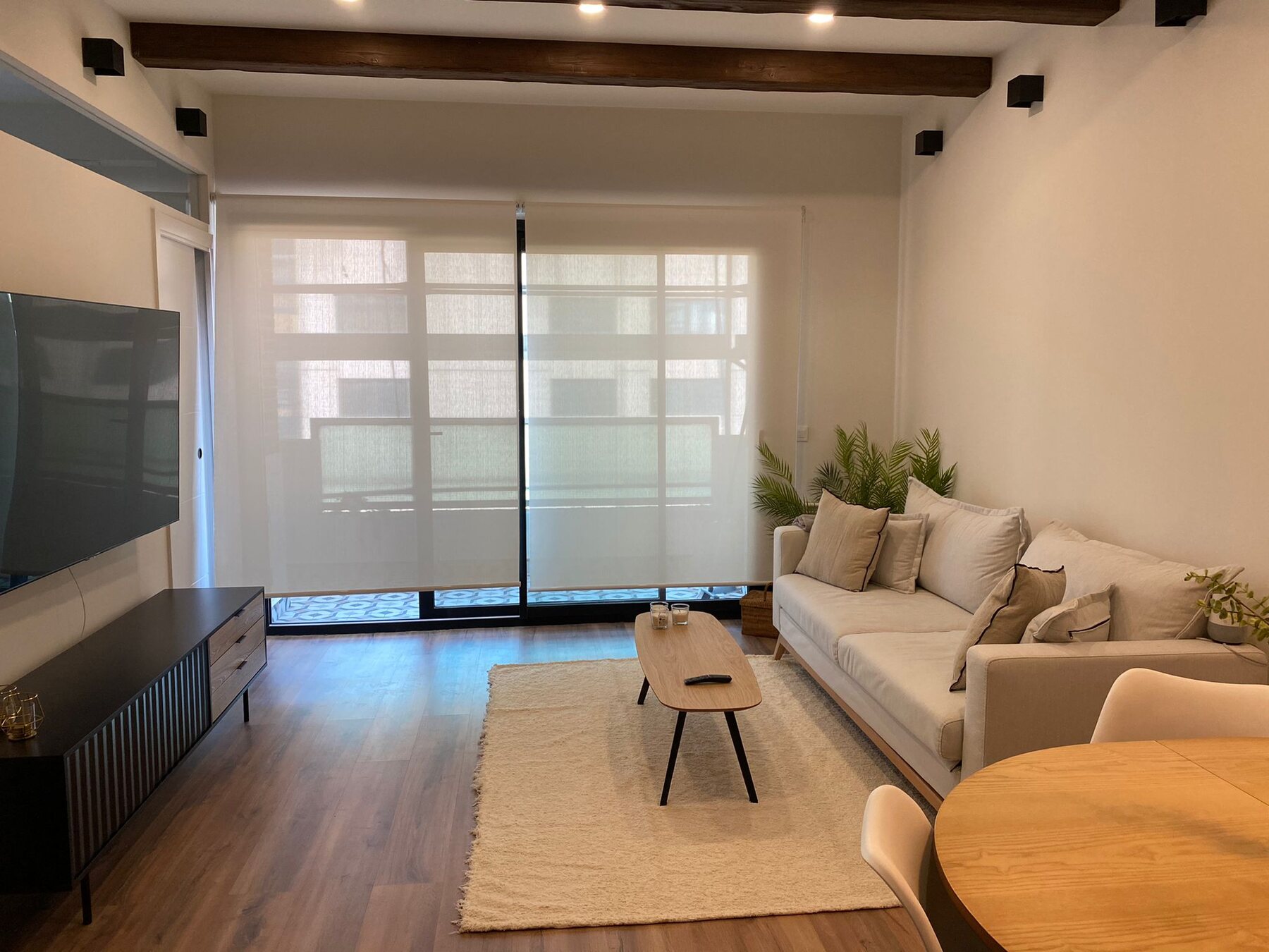 Salón luminoso de vivienda en Madrid con sofá y ventanal