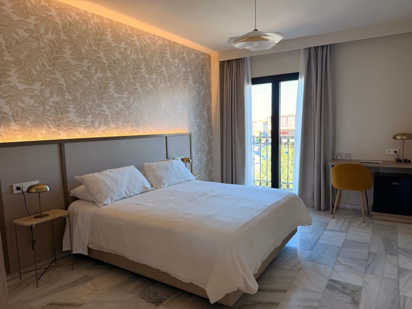 Habitación del hotel Zarú en Toledo con cabecero iluminado y ropa de cama blanca