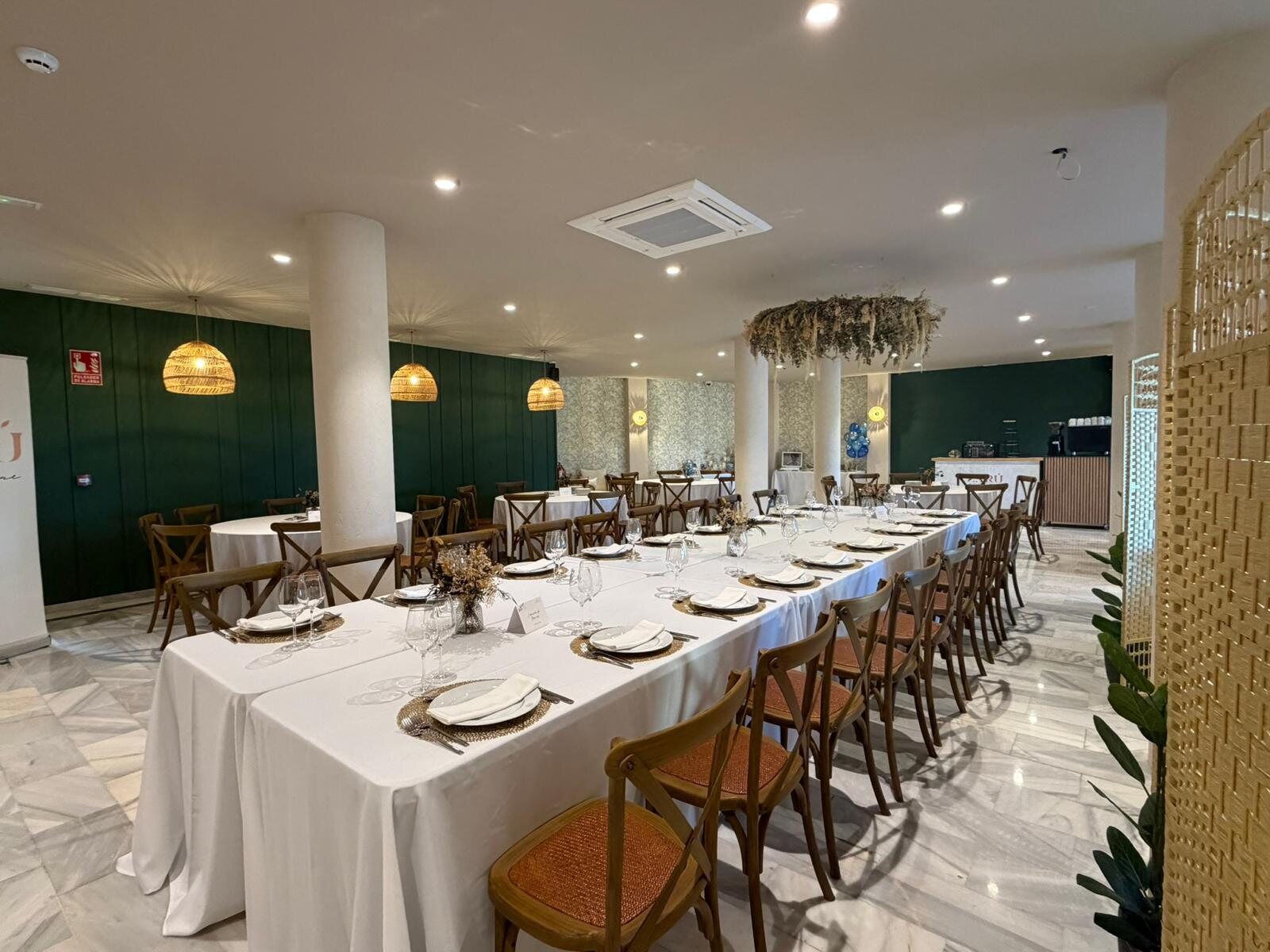 Sala del restaurante Zarú con mesas preparadas y pared verde