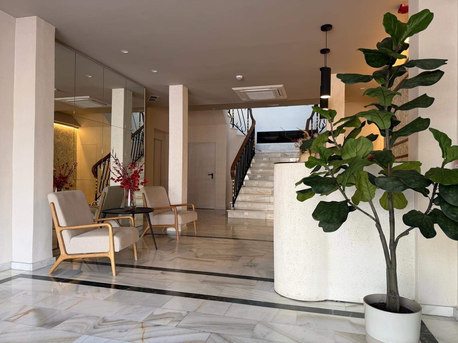 Recepción del hotel Zarú con mostrador curvo y vegetación interior
