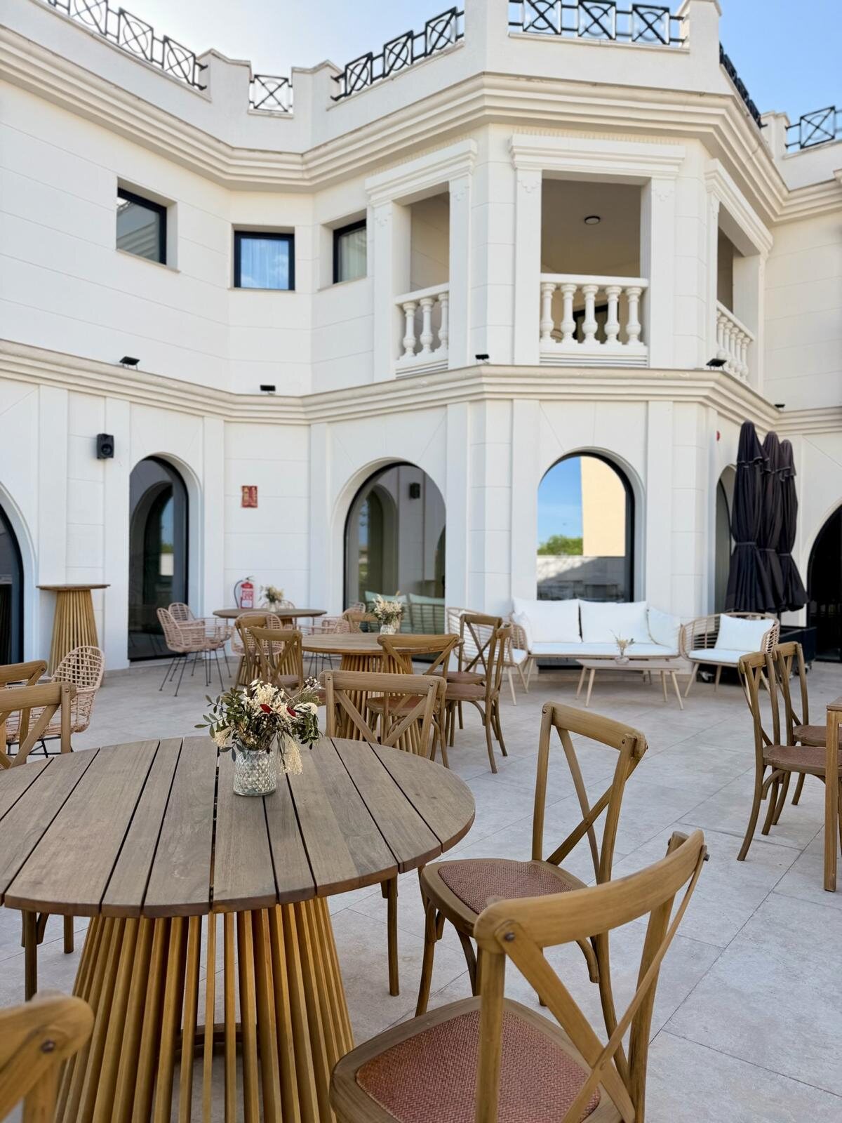 Patio del hotel Zarú con mesas y arquitectura blanca