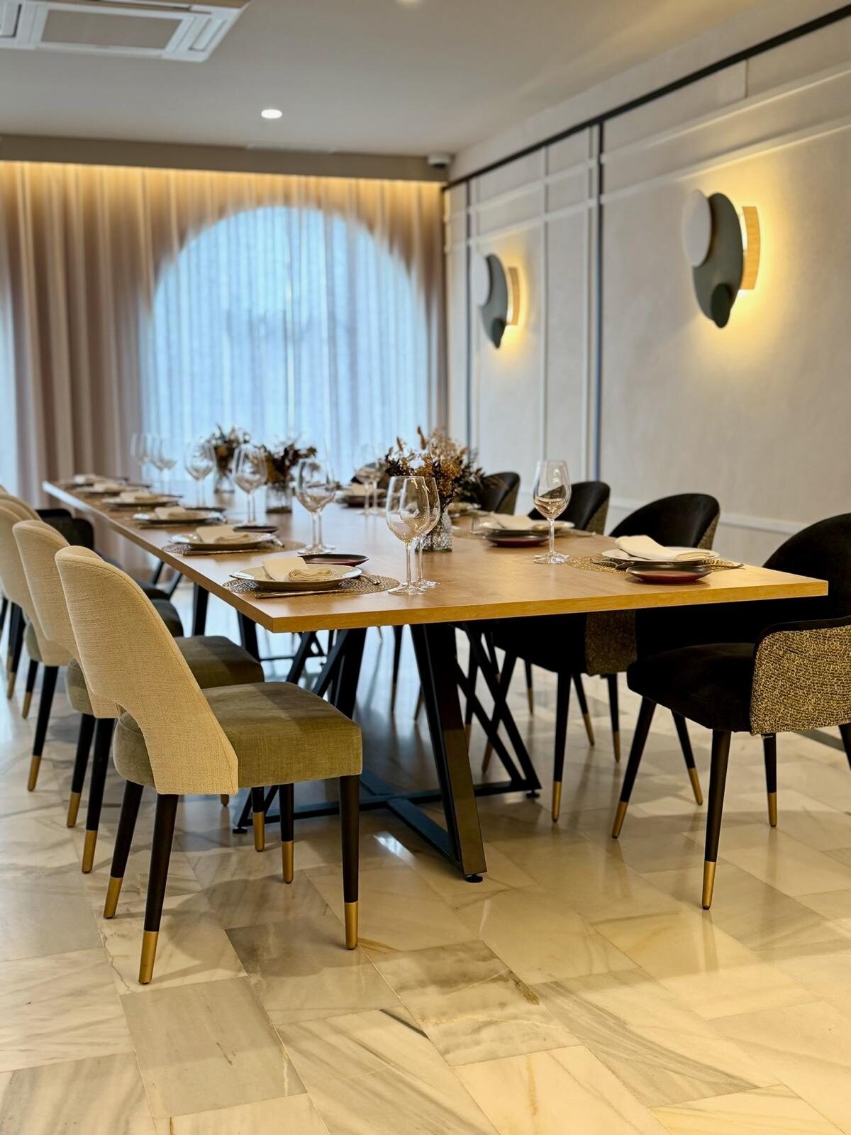 Comedor de Zarú con ventanal arqueado y mesa larga