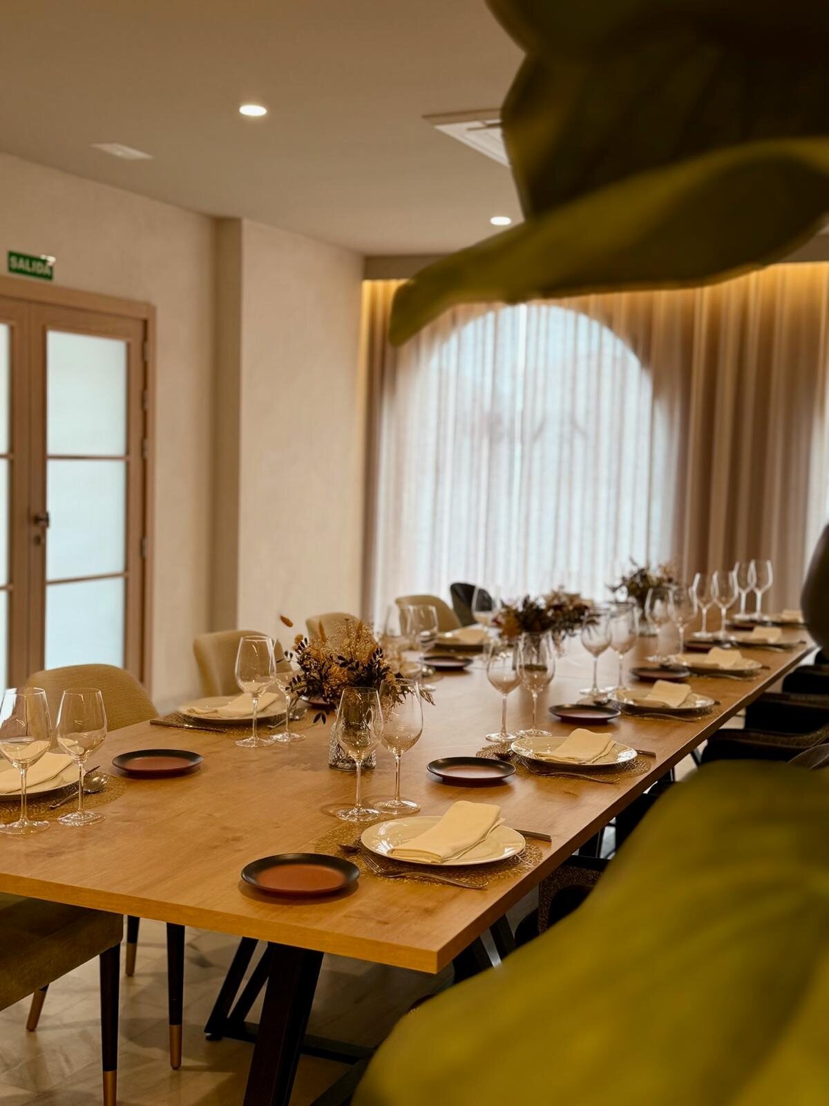 Mesa de restaurante Zarú bajo luz cálida y cortinas claras