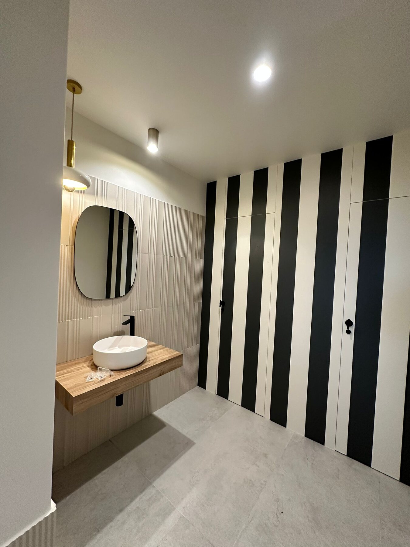 Aseo del hotel Zarú con lavabo claro y pared de listones oscuros