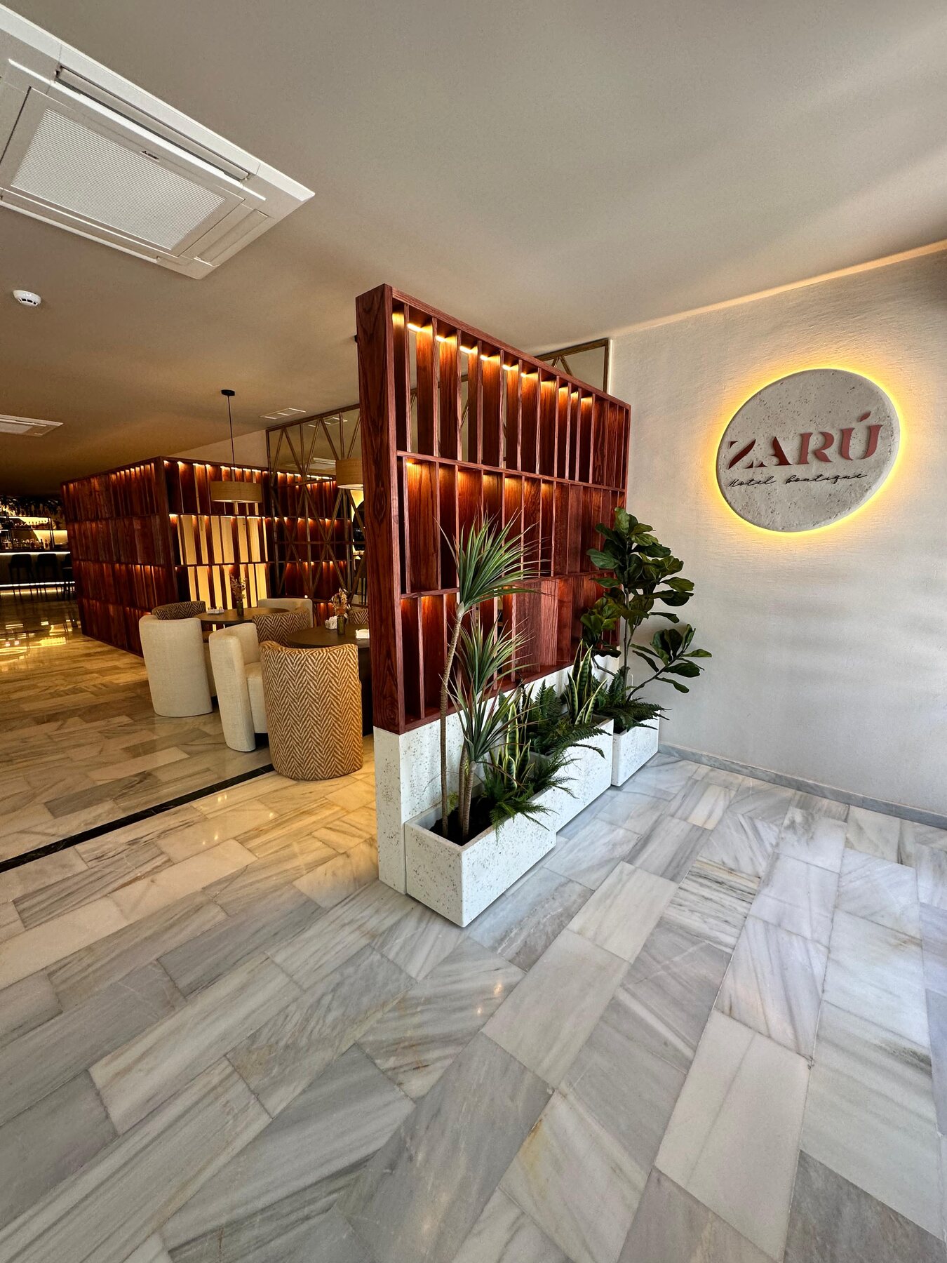 Entrada al hotel Zarú con iluminación cálida y elementos decorativos