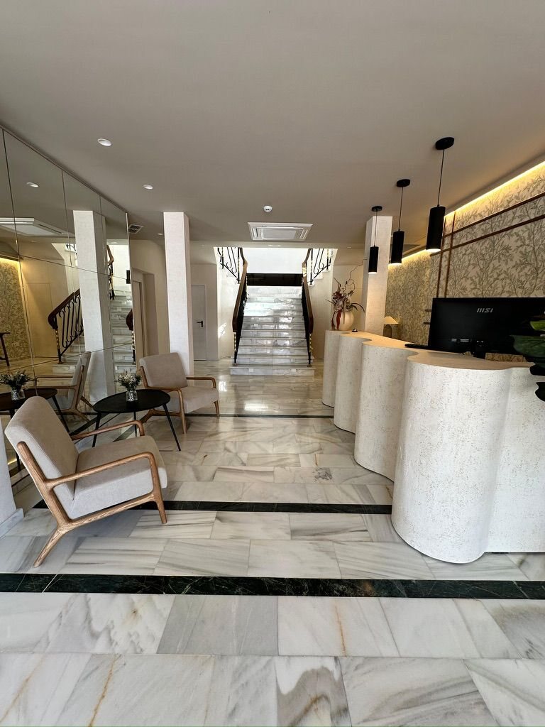 Recepción del hotel Zarú con mostrador de piedra y luminarias colgantes